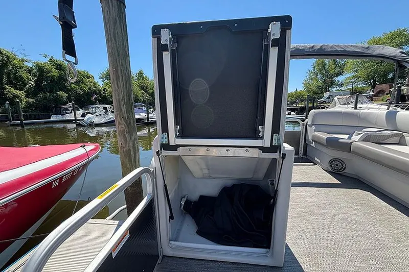 Slide: The Image of 2022 Godfrey Sweetwater 2286 SBX pontoon boat with open storage compartment at dock. - 12