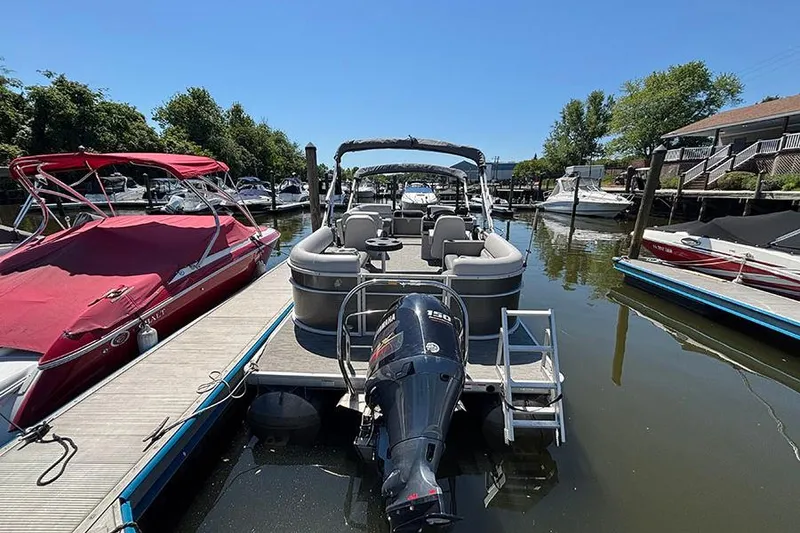 Slide: The Image of 2022 Godfrey Sweetwater 2286 SBX pontoon boat docked in a marina. - 2