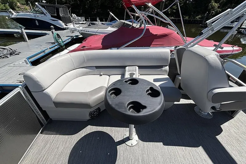 Slide: The Image of 2022 Godfrey Sweetwater 2286 SBX pontoon boat interior with seating and table at dock. - 5