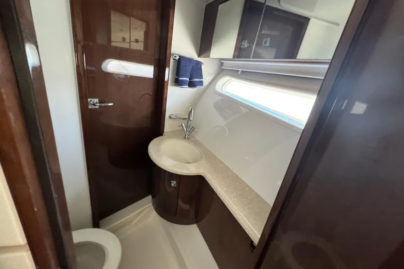 Slide: The Image of 2007 Marquis 55 LS yacht with sleek design and spacious upper deck against a clear blue sky. - 11