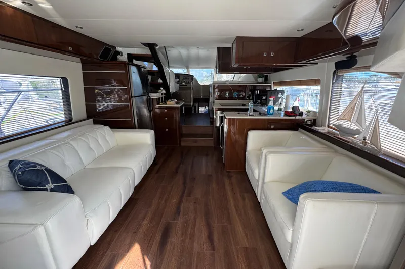 Slide: The Image of 2007 Marquis 55 LS yacht cruising near a scenic bridge on calm waters. - 2