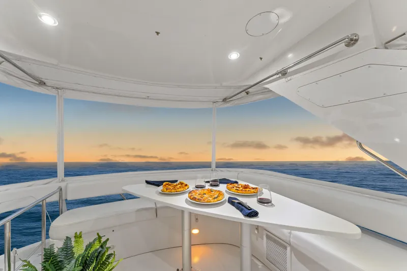 Slide: The Image of Luxury dining on 2007 Marquis 55 LS yacht at sunset, featuring pizza and wine. - 53