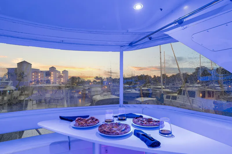Slide: The Image of Luxurious 2007 Marquis 55 LS yacht interior with pizzas and drinks at sunset marina. - 54