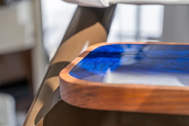 Slide: The Image of Close-up of a 2007 Marquis 55 LS yacht's elegant wooden and blue resin table. - 62
