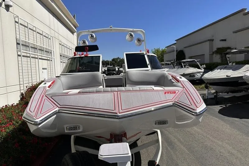 Slide: The Image of 2023 MB SPORTS F22 Tomcat Alpha boat, sleek design, parked outdoors under clear blue sky. - 4