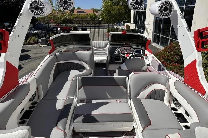 Slide: The Image of 2023 MB SPORTS F22 Tomcat Alpha boat interior with red and gray seating, speakers, and dashboard. - 6