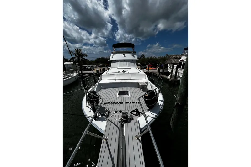 Slide: The Image of 1988 Chris Craft Constellation yacht docked under a cloudy sky. - 2