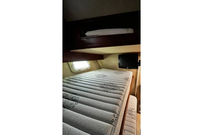 Slide: The Image of Interior cabin of 1988 Chris Craft Constellation with bunk beds and a small window. - 23
