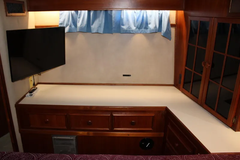 Slide: The Image of Interior of 1988 Chris Craft Constellation with TV, wooden cabinets, and blue curtains. - 38