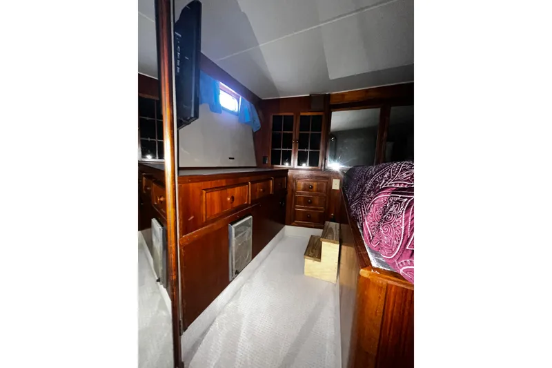 Slide: The Image of Interior of 1988 Chris Craft Constellation yacht with wooden cabinetry and patterned bedding. - 37