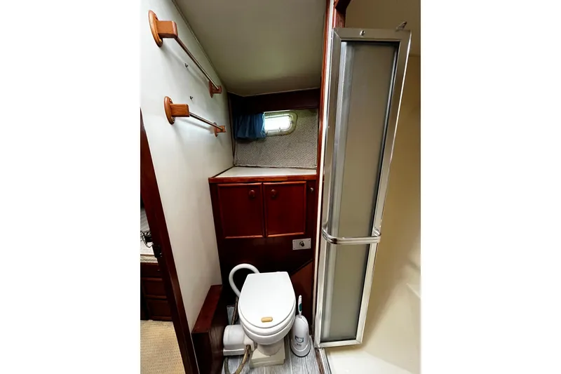 Slide: The Image of Bathroom interior of 1988 Chris Craft Constellation yacht, featuring wooden cabinets and compact design. - 27