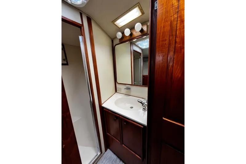 Slide: The Image of Bathroom interior of 1988 Chris Craft Constellation yacht with wooden cabinetry and mirror. - 24