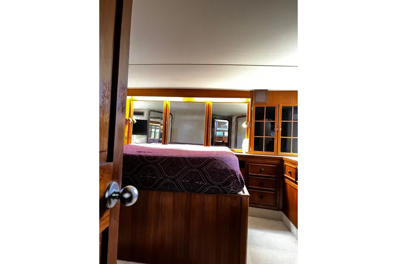 Slide: The Image of Luxurious 1988 Chris Craft Constellation yacht bedroom with wooden cabinetry and elegant decor. - 33