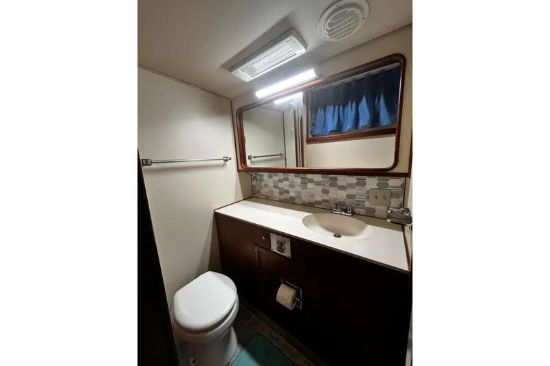 Slide: The Image of Bathroom interior of 1988 Chris Craft Constellation yacht, featuring sink, mirror, and toilet. - 31