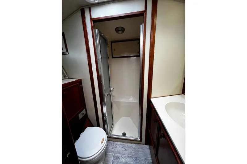 Slide: The Image of Bathroom interior of 1988 Chris Craft Constellation yacht, featuring shower, toilet, and sink. - 25