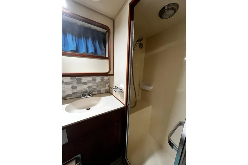 Slide: The Image of Bathroom interior of 1988 Chris Craft Constellation yacht, featuring sink and shower area. - 32
