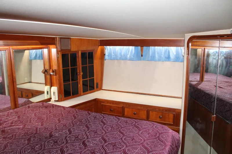 Slide: The Image of Luxurious 1988 Chris Craft Constellation cabin interior with wood accents and patterned bedding. - 34