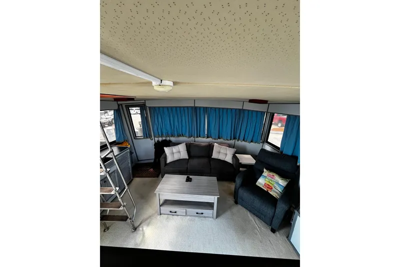 Slide: The Image of Interior of 1988 Chris Craft Constellation with cozy seating and blue curtains. - 8