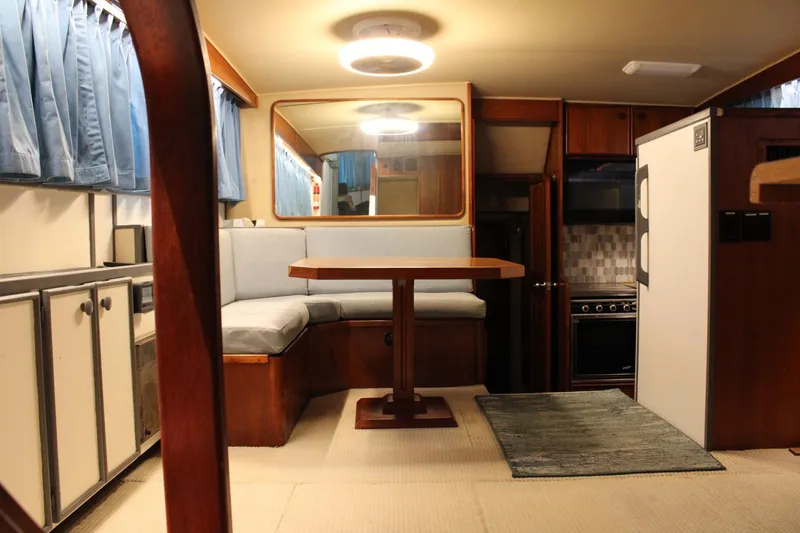 Slide: The Image of Interior of 1988 Chris Craft Constellation yacht with dining area and kitchen amenities. - 14