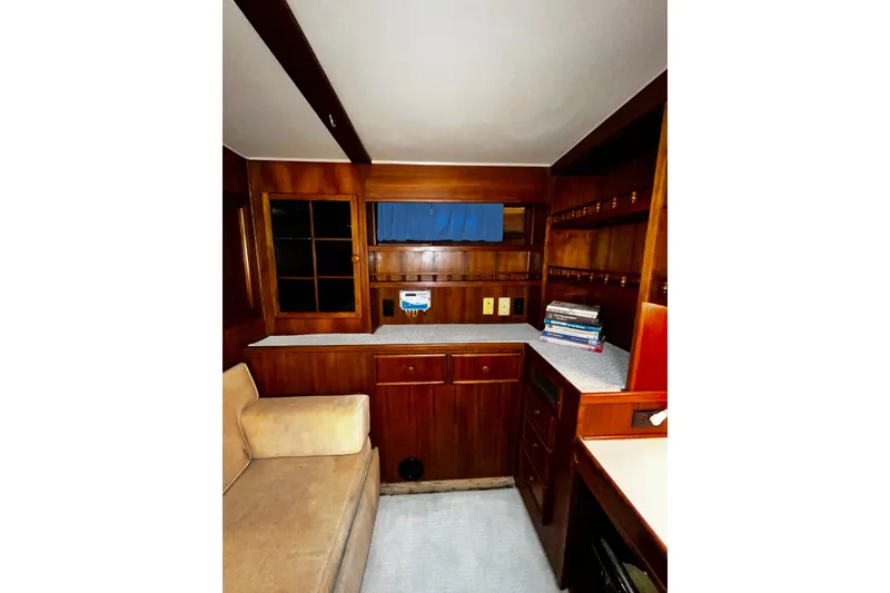 Slide: The Image of 1988 Chris Craft Constellation interior with wooden cabinetry and cozy seating area. - 26