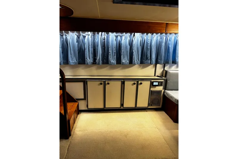 Slide: The Image of Interior of 1988 Chris Craft Constellation with blue curtains and vintage cabinetry. - 16