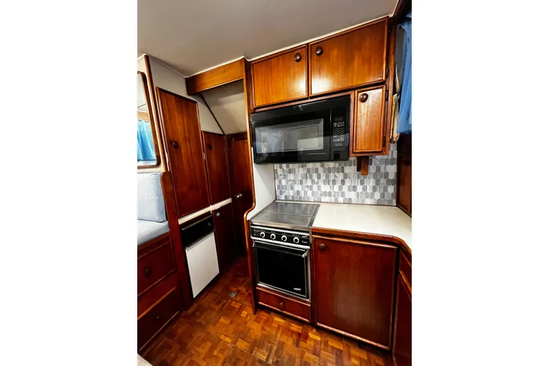 Slide: The Image of 1988 Chris Craft Constellation kitchen with wood cabinets, stove, and microwave. - 20