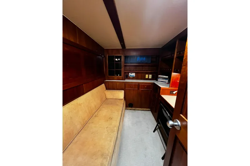 Slide: The Image of Interior of 1988 Chris Craft Constellation yacht with wood paneling and beige seating. - 28