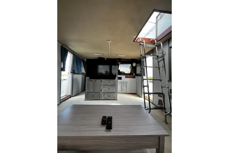 Slide: The Image of Interior of 1988 Chris Craft Constellation yacht with TV, ladder, and table. - 6