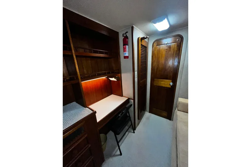 Slide: The Image of 1988 Chris Craft Constellation cabin interior with wooden desk, shelves, and fire extinguisher. - 30