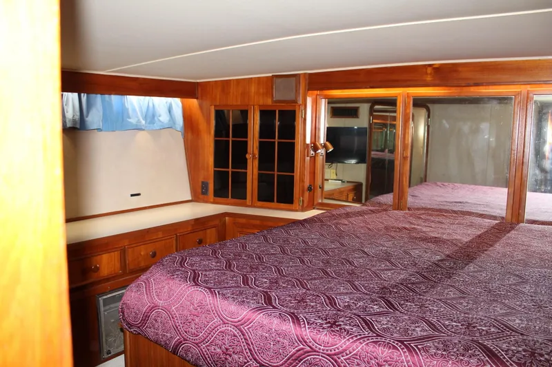 Slide: The Image of Luxurious 1988 Chris Craft Constellation cabin interior with wood paneling and purple bedding. - 35