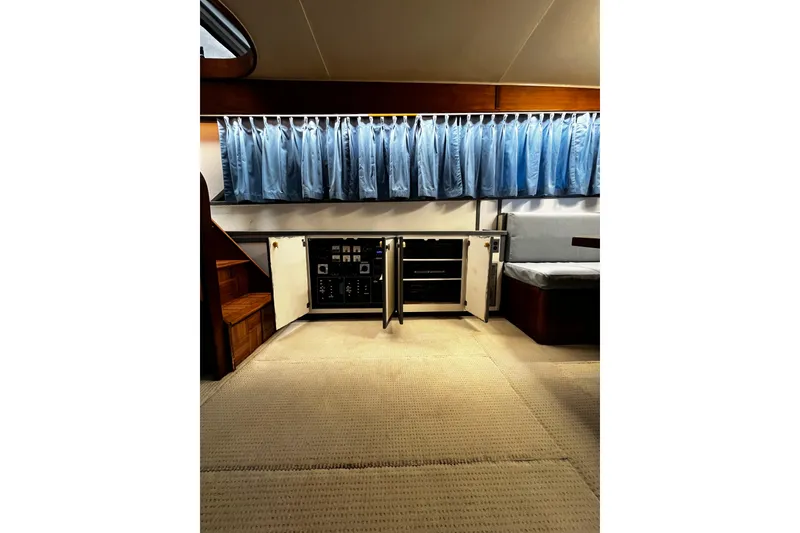 Slide: The Image of Interior of 1988 Chris Craft Constellation yacht with open cabinet and blue curtains. - 17