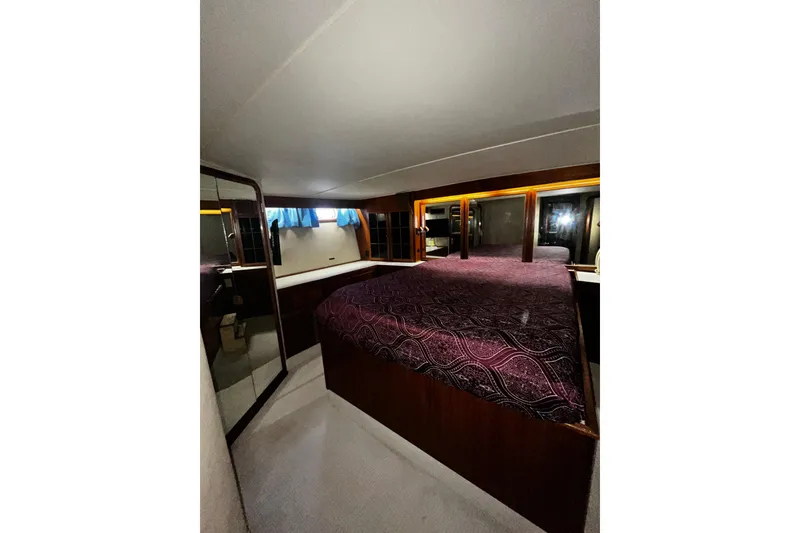 Slide: The Image of Luxurious cabin interior of 1988 Chris Craft Constellation yacht with elegant bedding and wood accents. - 36