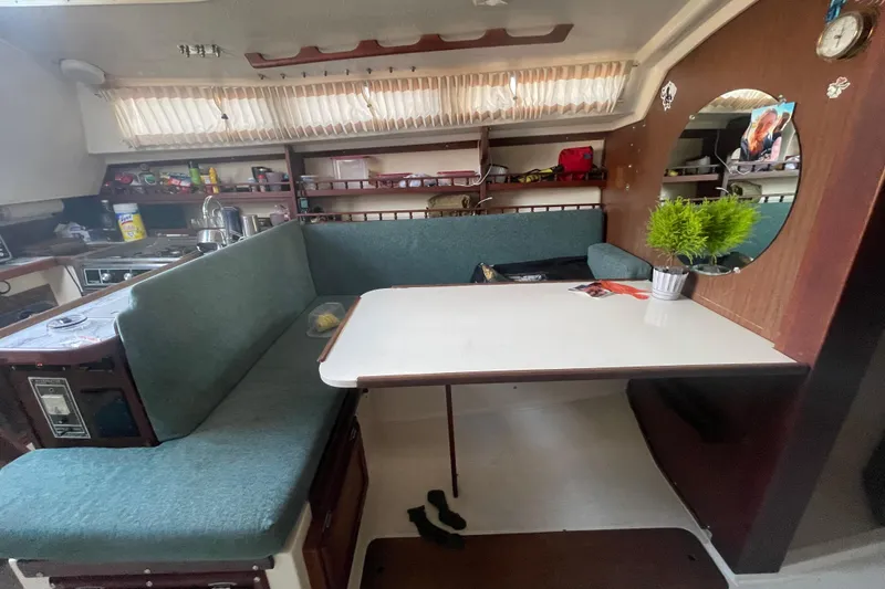Slide: The Image of 1977 Catalina boat interior with dining area, green seating, and wooden accents. - 11