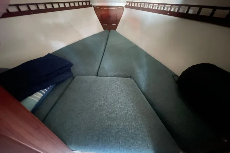 Slide: The Image of 1977 Catalina boat interior with V-berth cushions and wooden accents. - 14