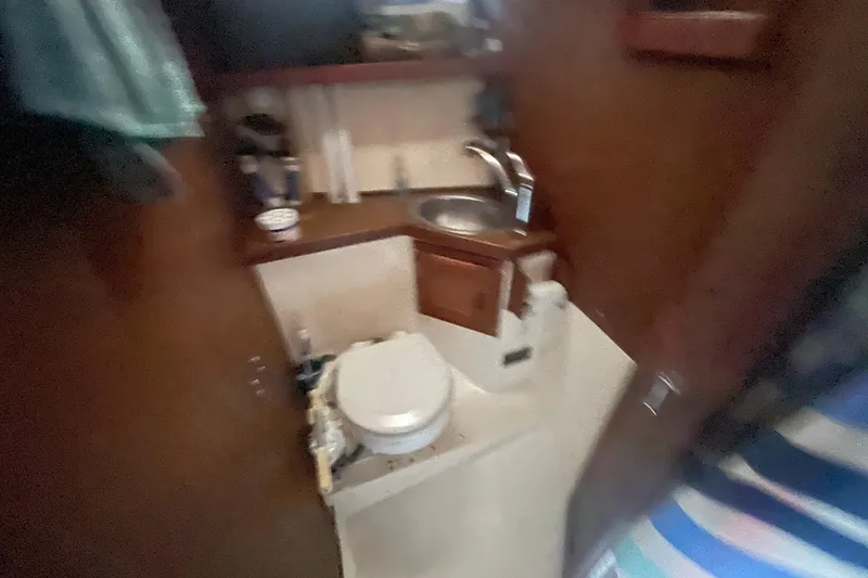 Slide: The Image of 1977 Catalina boat bathroom with sink, toilet, and wooden cabinetry. - 17