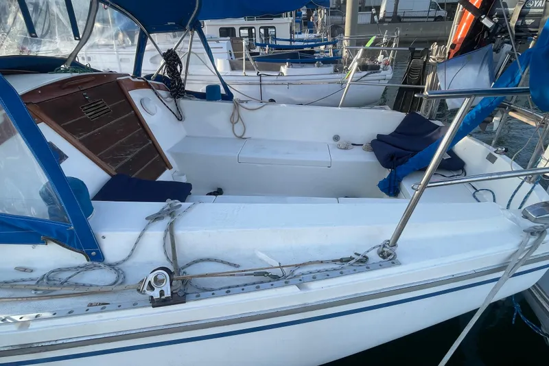 Slide: The Image of 1977 Catalina sailboat with blue canopy and seating, docked at marina. - 4