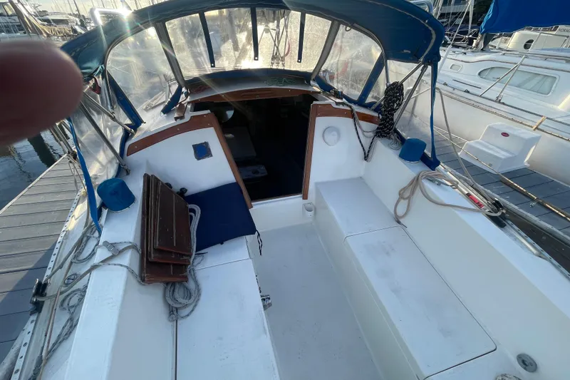 Slide: The Image of 1977 Catalina sailboat cockpit with blue canopy, docked at marina. - 5