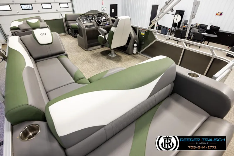 Slide: The Image of 2024 Avalon LSZ CRB pontoon boat interior with green and gray seating, steering console, and cup holders. - 11