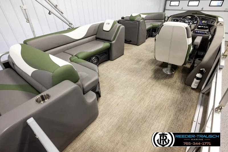 Slide: The Image of 2024 Avalon LSZ CRB pontoon boat interior with green and gray seating, steering console, and carpeted floor. - 12