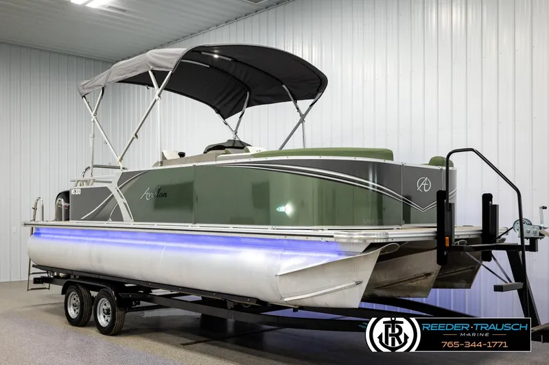 Slide: The Image of 2024 Avalon LSZ CRB pontoon boat with canopy on trailer in indoor showroom. - 3