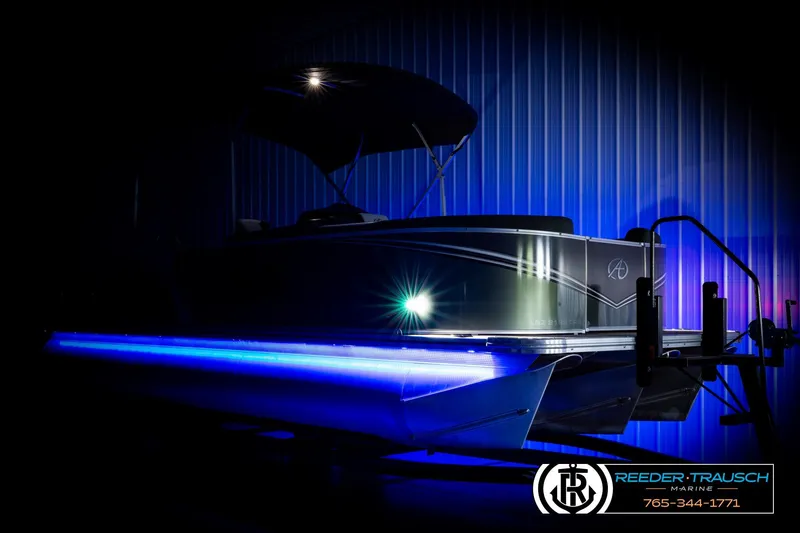 Slide: The Image of 2024 Avalon LSZ CRB pontoon boat with blue LED lights in a dimly lit setting. - 4
