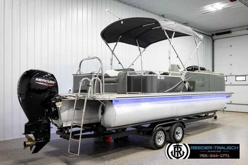 Slide: The Image of 2024 Avalon LSZ CRB pontoon boat with Mercury engine in indoor showroom. - 6
