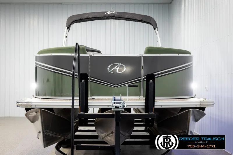 Slide: The Image of 2024 Avalon LSZ CRB pontoon boat in showroom, front view with logo and trailer. - 8