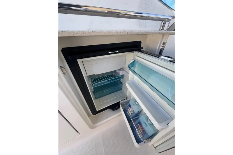 Slide: The Image of Open mini fridge on 2010 Searay 330 Sundancer yacht, stocked with beverages. - 13