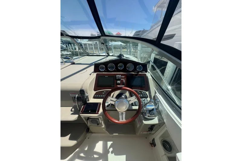Slide: The Image of Interior of 2010 Searay 330 Sundancer boat with steering wheel and seating area. - 16