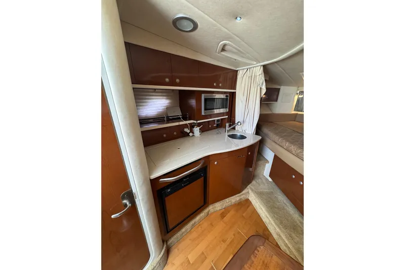 Slide: The Image of Interior of 2010 Searay 330 Sundancer yacht with wood cabinetry and beige seating. - 23