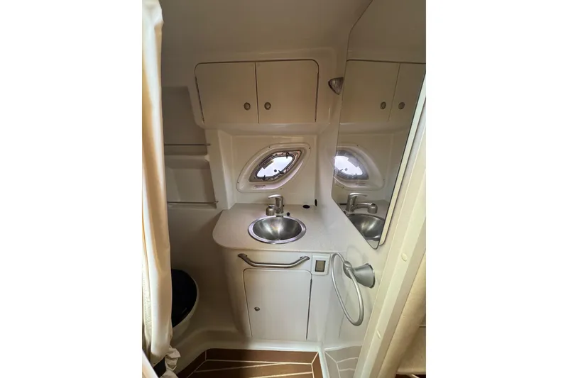 Slide: The Image of 2010 Searay 330 Sundancer bathroom with sink, toilet, and storage cabinets. - 25