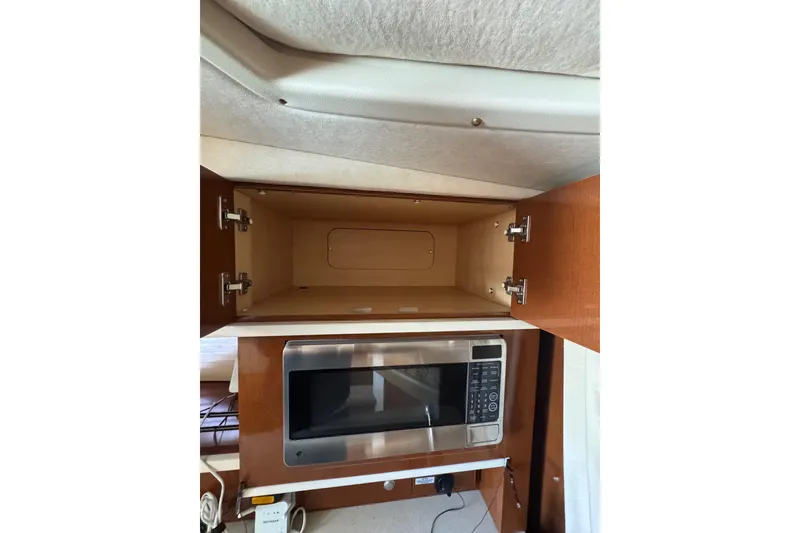 Slide: The Image of Interior cabinet of 2010 Searay 330 Sundancer boat, featuring open storage space. - 28
