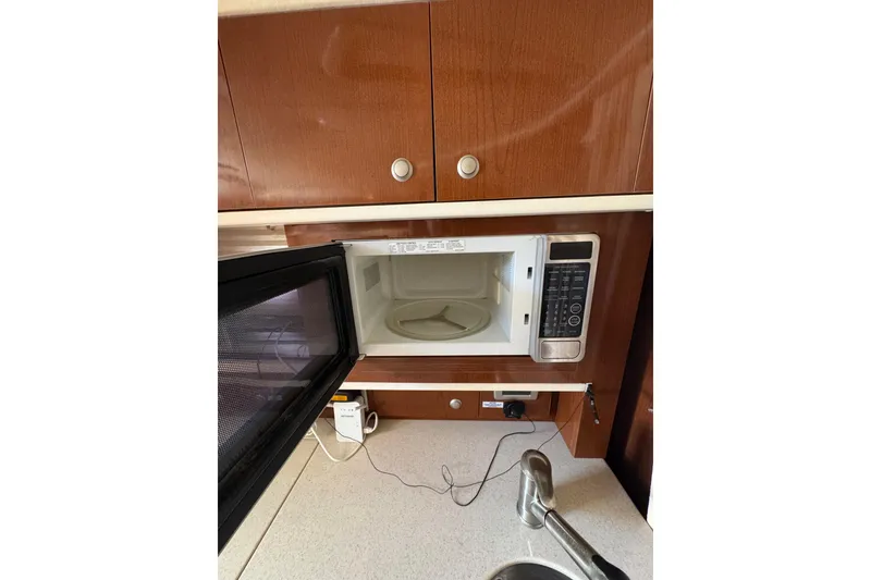 Slide: The Image of Interior of 2010 Searay 330 Sundancer showing microwave and open cabinet. - 29