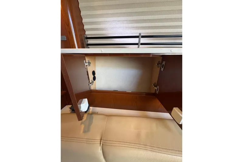 Slide: The Image of Interior cabinet of 2010 Searay 330 Sundancer with manuals and storage space. - 38